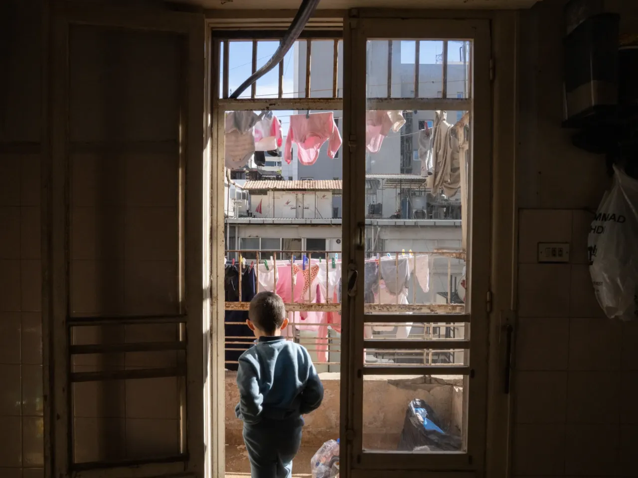 Born in south Lebanon, displaced to Beirut, two grandmothers reflect on Israeli invasions 5 Baby clothes hang from clotheslines on the balcony of the apartment where the family is staying.