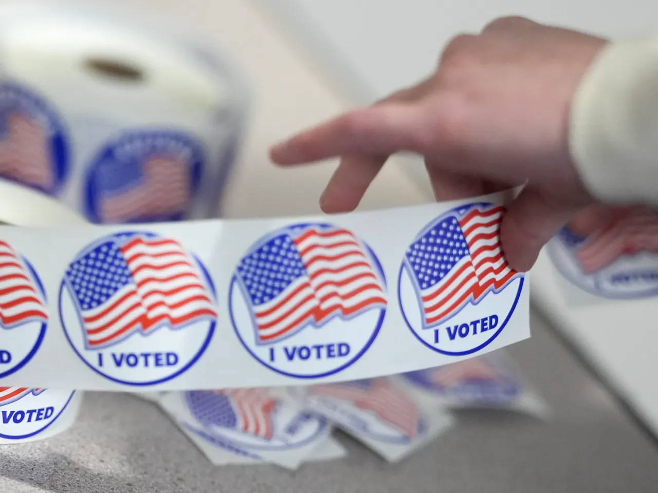 An election worker tears off "I Voted" stickers during the Virginia redistricting referendum at Fairfax Government Center, Tuesday, April 21, 2026, in Fairfax, Va.