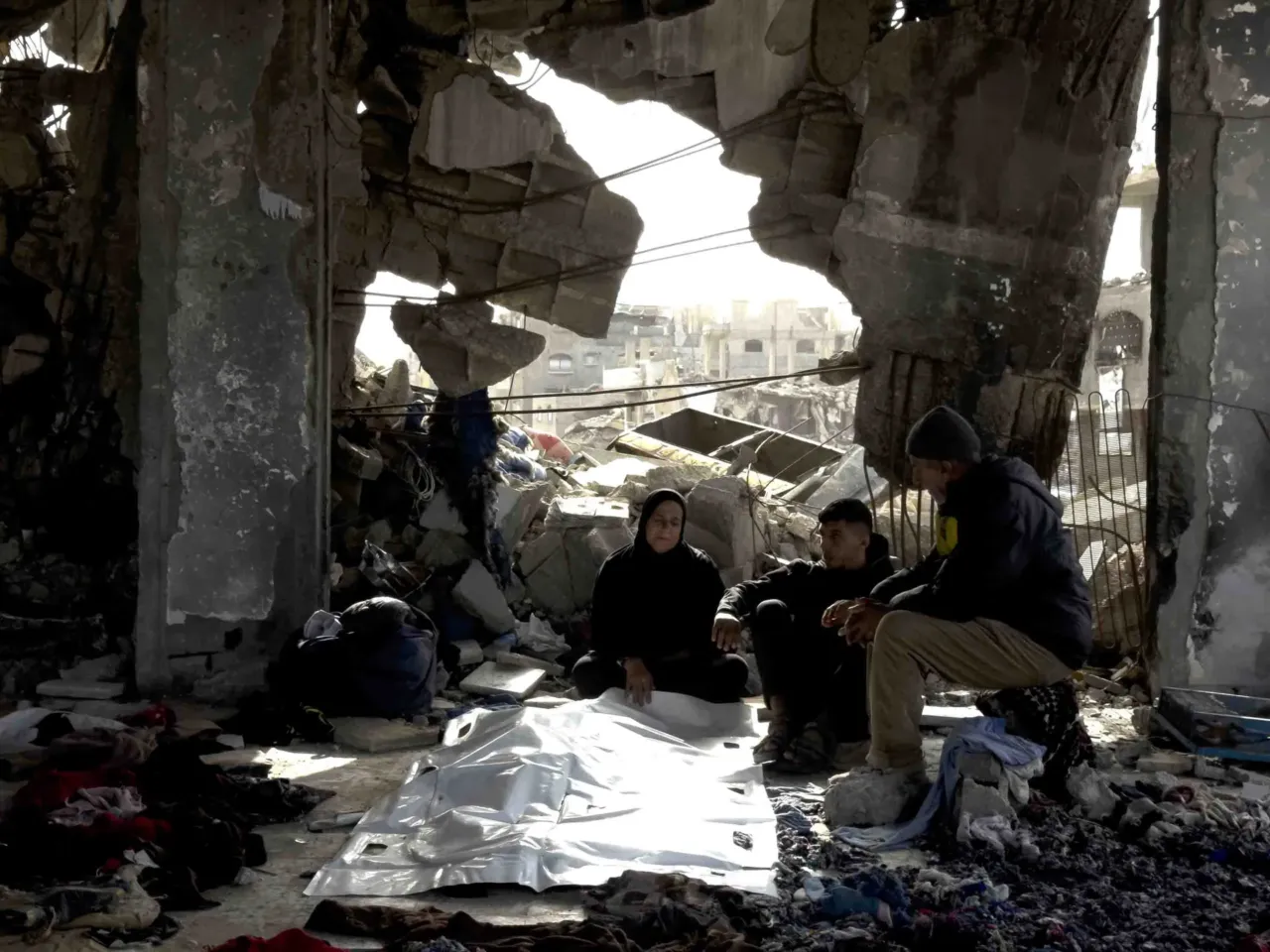 Skeletons in their clothing: Recovering bodies from the rubble in Gaza 5 Members of the Abu Naser family sit beside the body of one of the victims recovered nearly a year and a half after their family's apartment building was struck in northern Gaza.