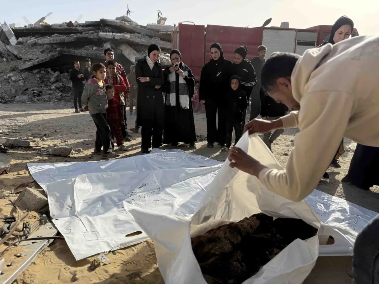 Skeletons in their clothing: Recovering bodies from the rubble in Gaza 6 Mohammed Abu Naser, 35, a survivor of the strike, bids farewell to his deceased uncle Shawqi Abu Naser, whose body and dozens of others were recovered from beneath the rubble of the family's home destroyed in an Israeli strike, as other family members gather.