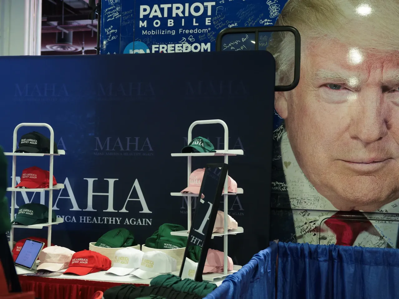"Make America Healthy Again" merchandise is sold in front of a bus with President Trump's image during the Conservative Political Action Conference at the Gaylord National Resort & Convention Center on Feb. 21, 2025, in Oxon Hill, Md. The Trump administration's approach to some issues dear to MAHA threatens to drive a wedge within the movement's ranks.
