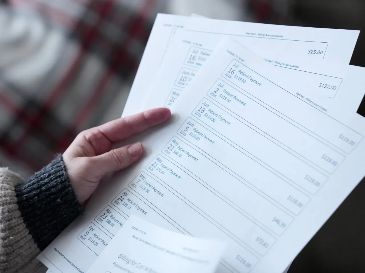 Cori Roberts, who was sued by her healthcare provider after she was unable to make full payments for her treatment, thumbs through copies of her payment records at her home in St. Cloud, Minnesota.
