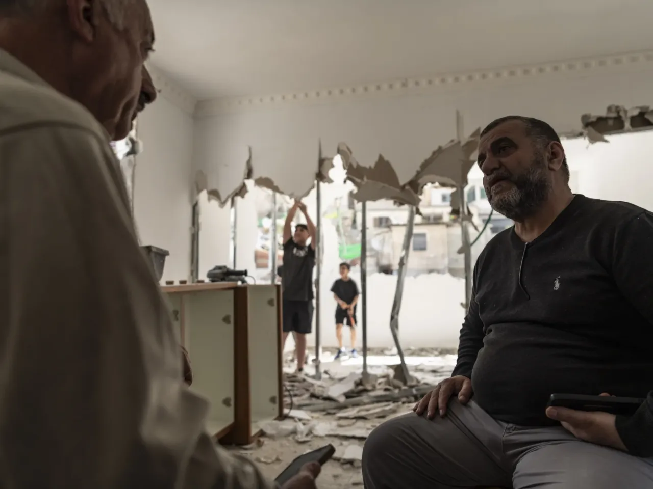 Israel's trying to expel a whole Palestinian district in East Jerusalem, activists say 4 Omar Abu Rajab, 60, chats with his neighbor while his nephews Ouday 13, left, and Brahim 11, right, work on the demolition of their house following the order of the Jerusalem Municipality, in the annexed East Jerusalem district of Silwan.