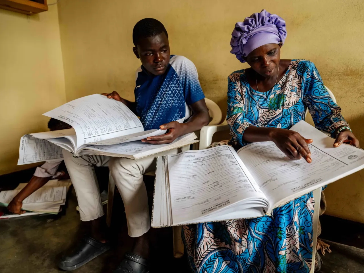 Photos show the world's 'uncounted' people -- and what it takes to be counted 1 June 11, 2025. Musanze District, Rwanda Goodlive Nyiramajyambere (left), Hosee Nziyonemeye (center) and Icamdenien Uwamahoro (right), sort through the paper archives searching for birth and death registration of their relatives at the Civil Registration Office. While Rwanda is actively digitizing all papercivil records, physical copies are still required for some official procedures. The transition to digital systems aims to improve accessibility.