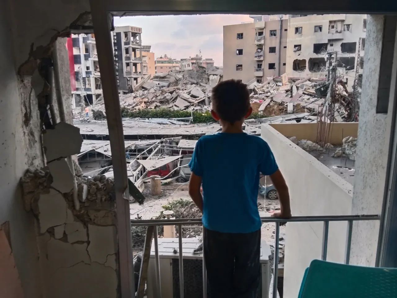 A boy looks through a damaged room of the Jabal Amel Hospital into a destroyed building that was hit in an Israeli airstrike in the southern port city of Tyre, Lebanon, June 1, 2026.