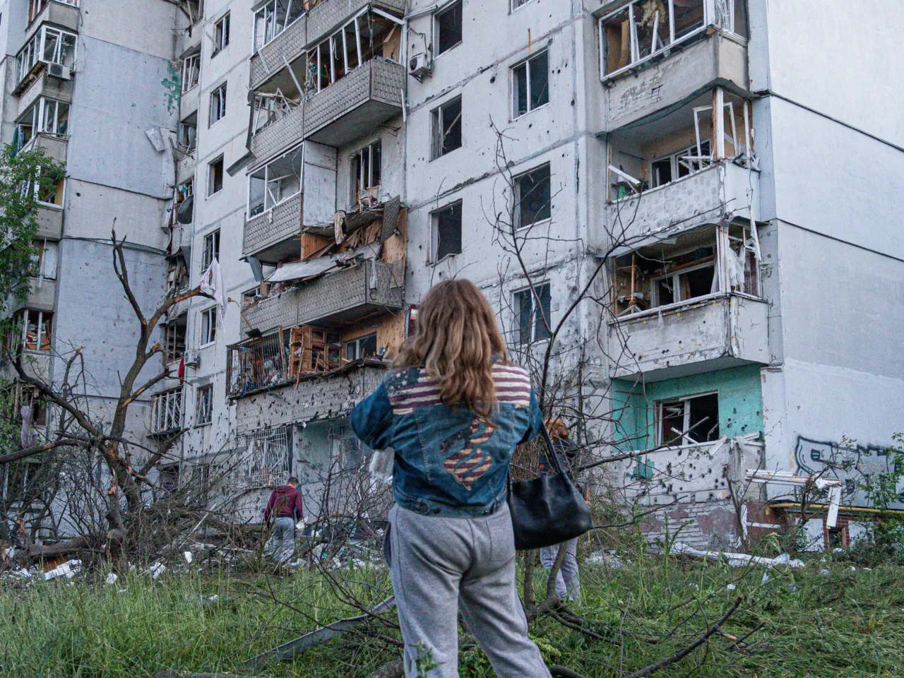A woman stands outside of an apartment building after the night attack on Kyiv, Ukraine.