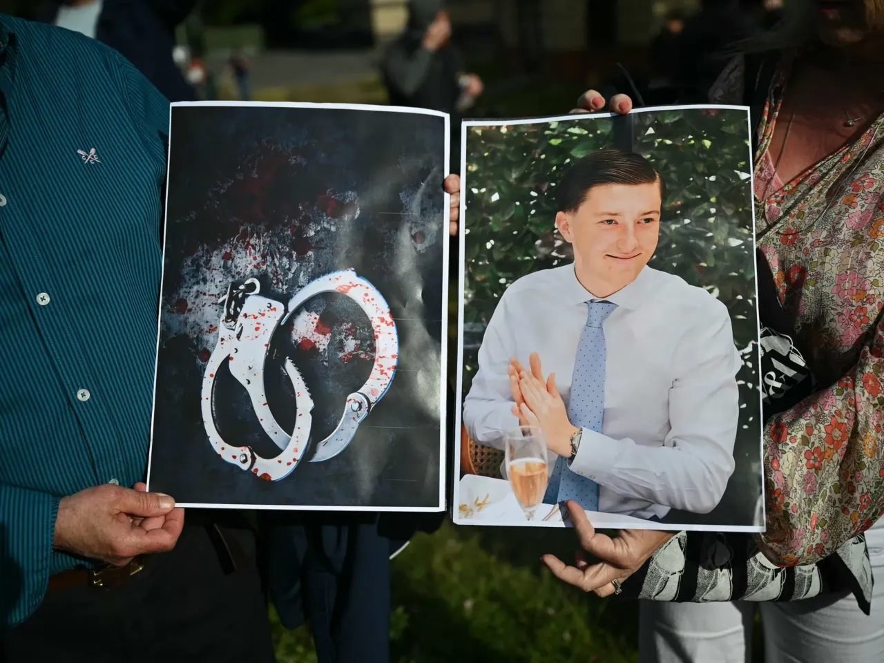 People hold images of victim Henry Nowak, and blood-covered handcuffs as they take part in a protest outside of Southampton Central Police Station in Southampton, southern England, on June 2, 2026, following the murder of Henry Nowak by Vickrum Digwa.