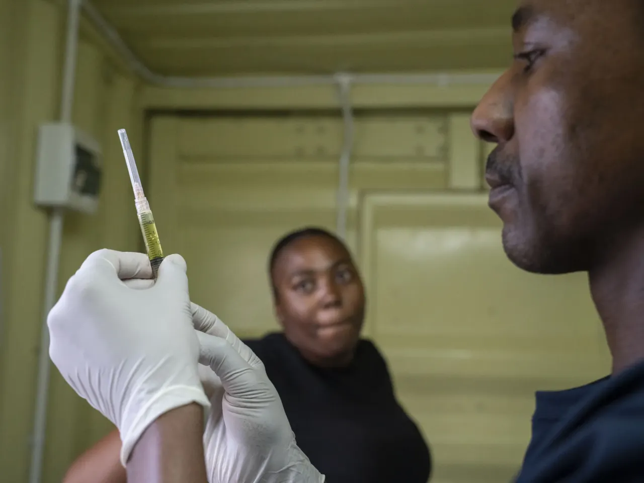 Nurse Mpho Matloane  prepares a syringe filled with the drug Lenacapavir which he prepares to administer to Kegoratile Aphane (left) at the Phedisong clinic in Ga-Rankuwa, north-west of Pretoria, on Dec. 2, 2025.