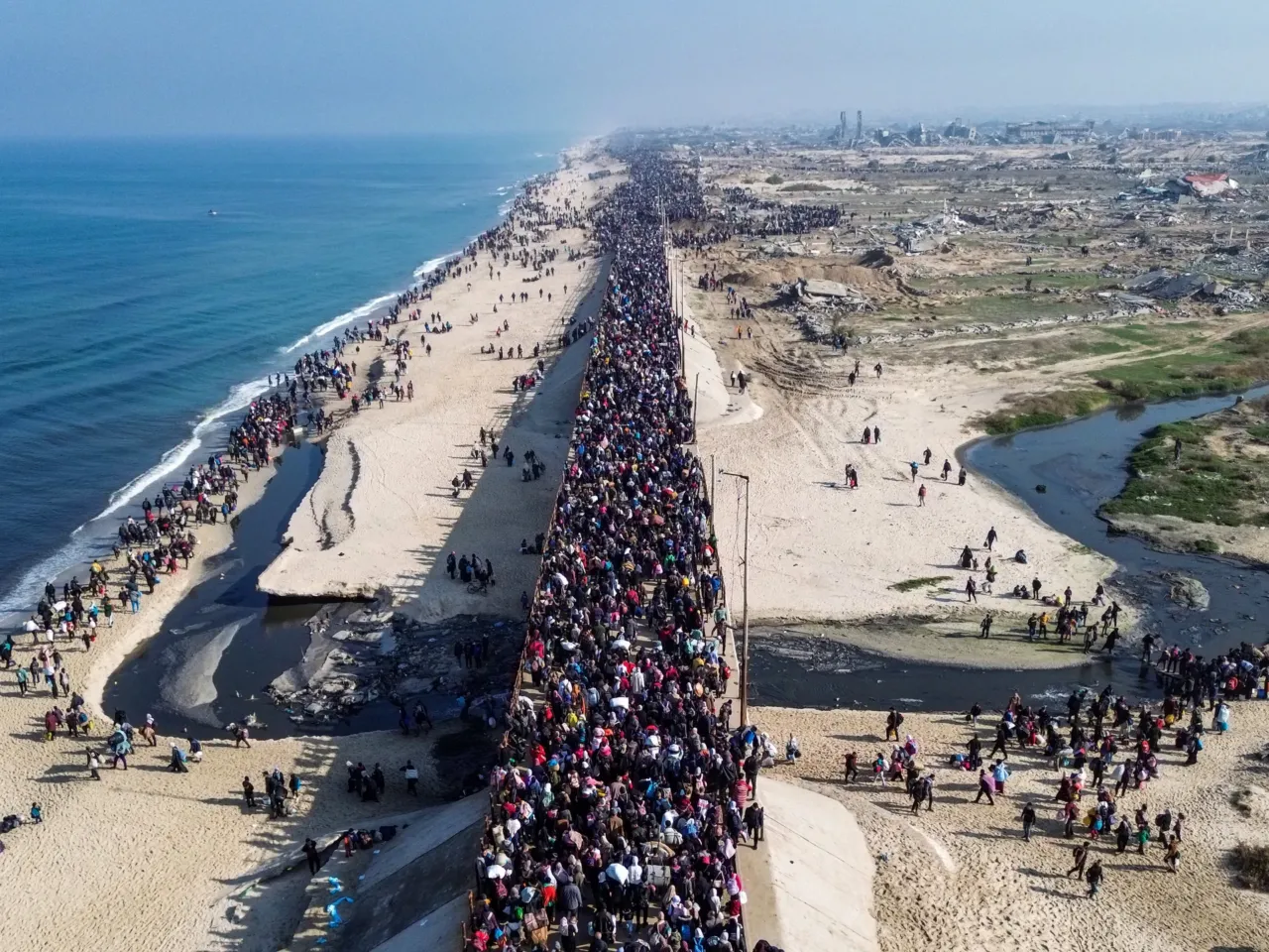 This aerial photo shows displaced Gazans walking toward Gaza City on January 27, 2025, after crossing the Netzarim corridor from the southern Gaza Strip.