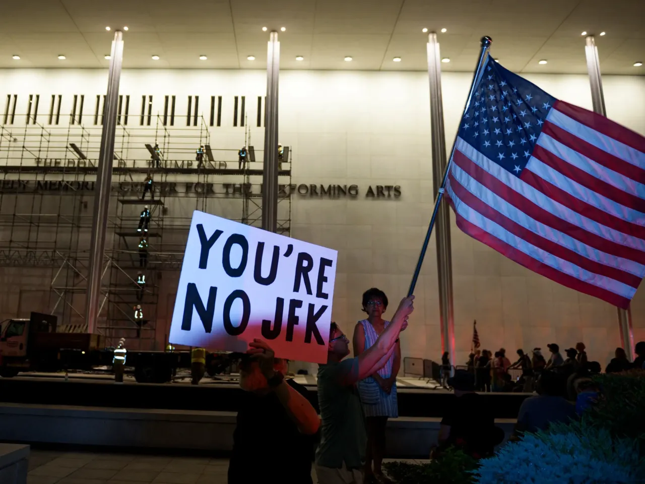 Kennedy Center removes Trump's name from the building 1 Protestors wave a U.S. and signs as workers prepare to remove President Donald Trump's name from the John F. Kennedy Center for the Performing Arts in Washington, Saturday, June 13, 2026.