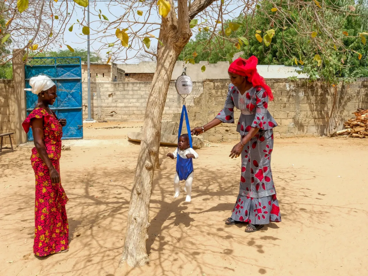 Adama Faye (right), a community health worker, weighs the son of Ndiolle Diouf at the health clinic in the village of Keur Mbar to determine if he is malnourished.