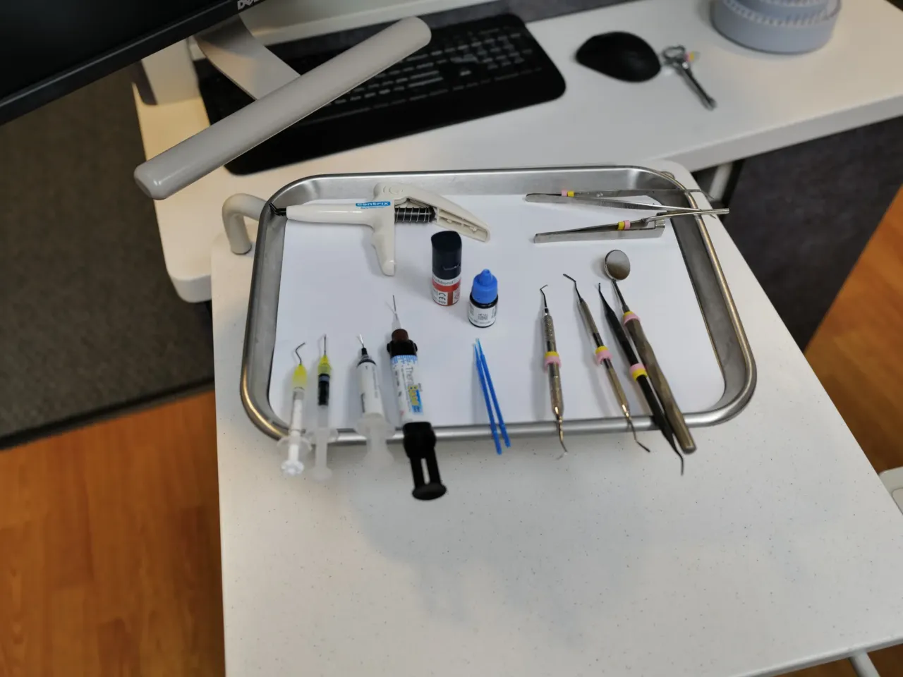 Dental tools used for routine examinations sit on a tray at a dental office.