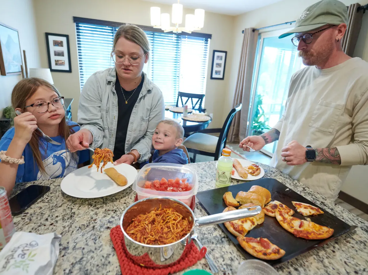 Amber and Neil Petersen serve lunch to two of their children, 11-year-old Eden and 4-year-old Jack, while visiting Amber's parents in Iowa City, Iowa.