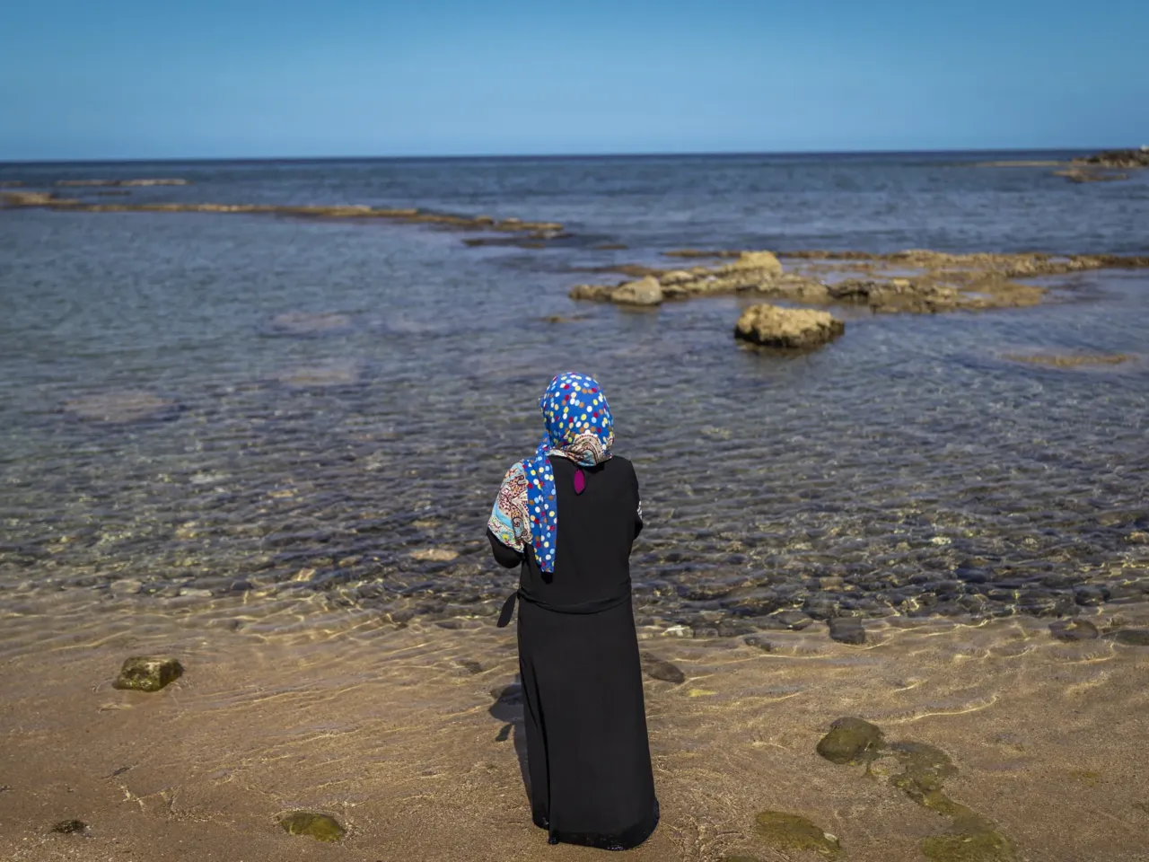Lebanese struggle to get by in an ancient city under Israeli evacuation order 8 Mimi Istanbouli, a displaced schoolteacher, looks out over the sea. Her home was destroyed, and she is sheltering in a theater with her ill mother.