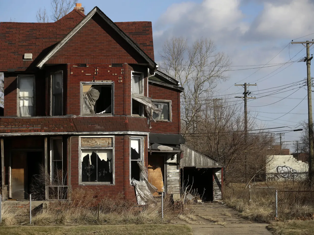 When falling housing prices are good news — and when they're not 1 TO GO WITH AFP STORY by Joe Szczesny, US-city-Detroit-auto-debt
Curtains flap outside the broken window of an abandoned home December 31, 2014 in Detroit, Michigan. After the largest municipal bankruptcy in US history, Detroit hopes outsiders will see the city's potential not the history of racial conflict, financial crises and citizen flight that has cut its population in half since 1960. AFP PHOTO/JOSHUA LOTT (Photo credit should read Joshua LOTT/AFP via Getty Images)
