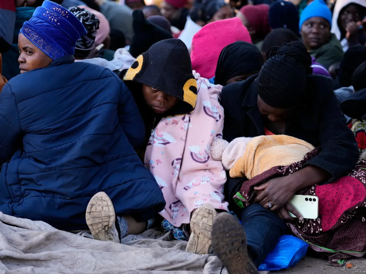 Malawian migrants sit on a driveway ahead of their deportation at a temporary center in Durban, South Africa, on June 19.