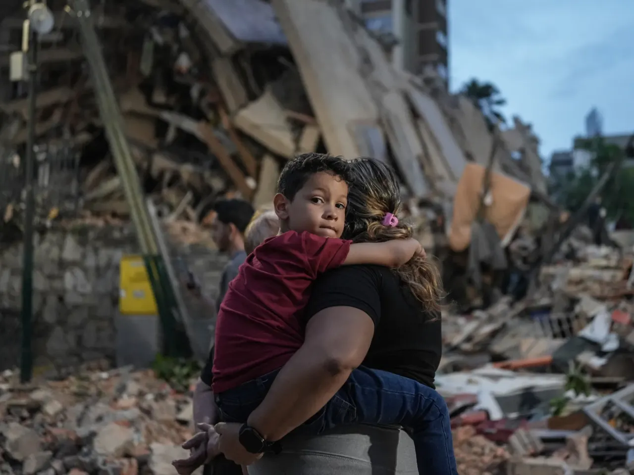 People walk past a collapsed building following an earthquake in Caracas on June 25, 2026.
