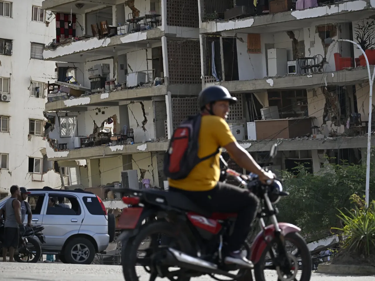 Residents look at a damaged apartment building following an earthquake in Catia La Mar, La Guaira state, about 30 km northwest of Caracas, on June 25, 2026.