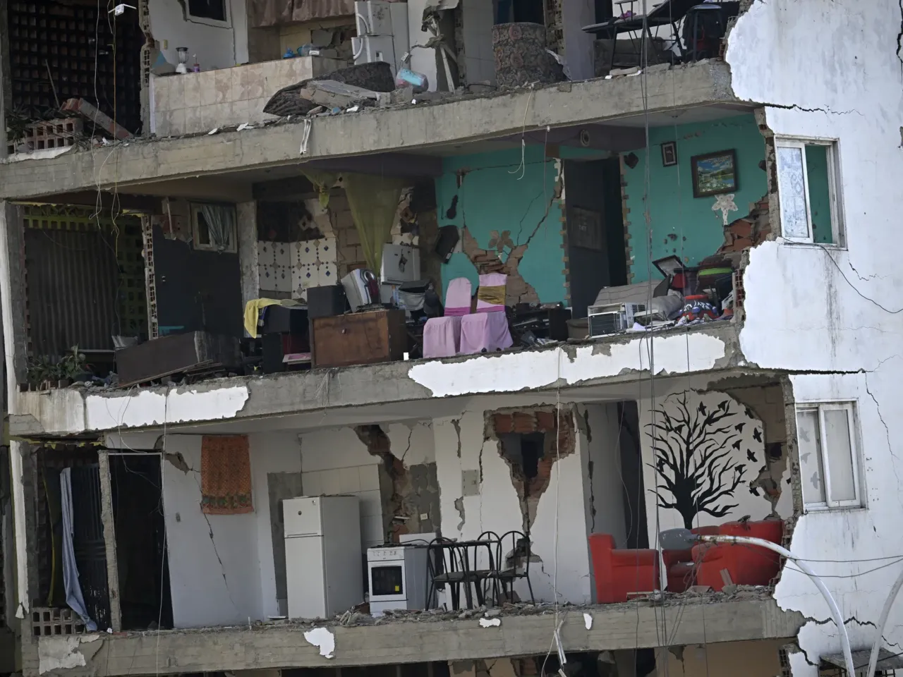 A view shows the interior of a heavily damaged apartment building following an earthquake.