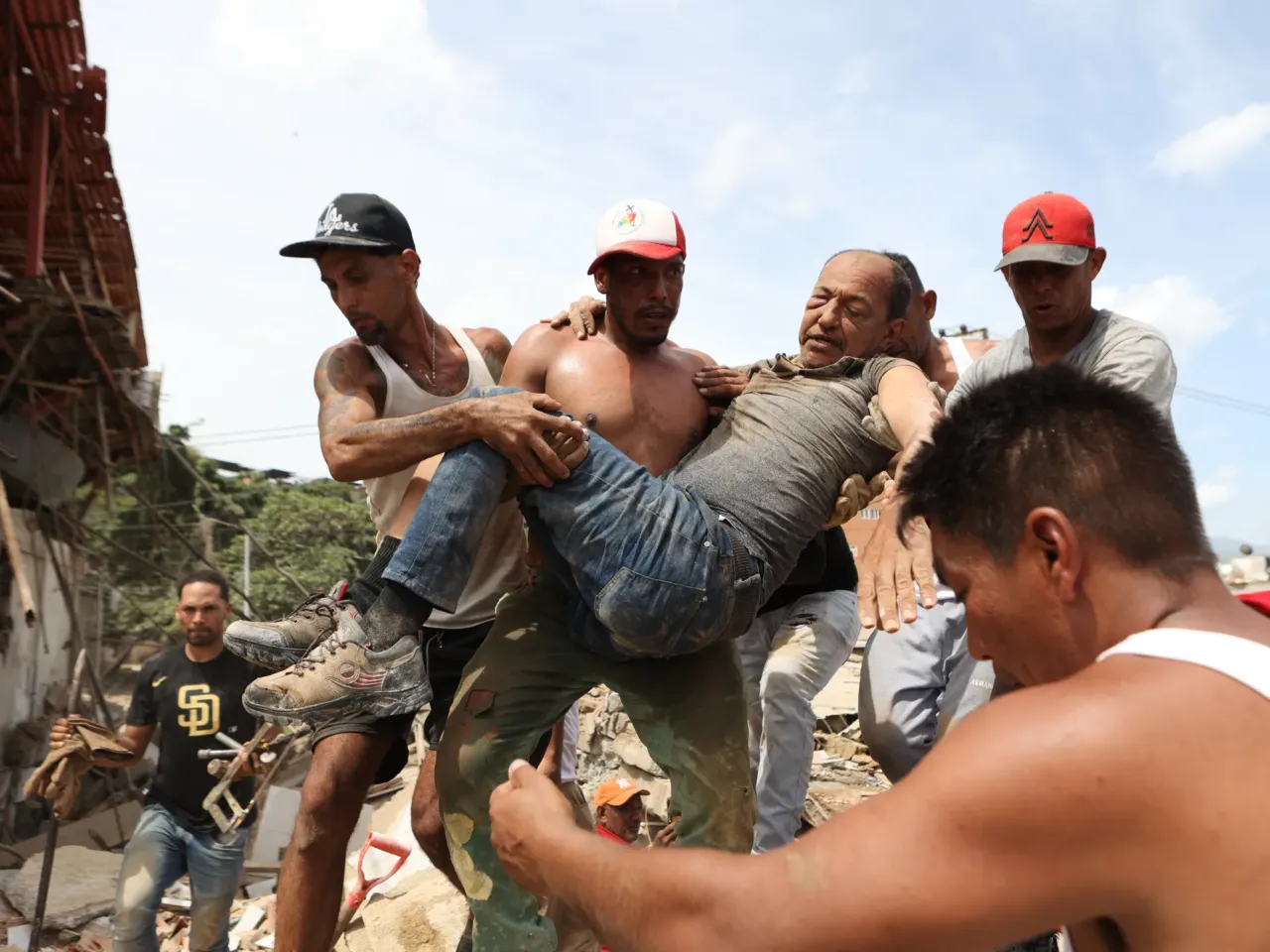 Venezuela is reeling from earthquakes, as the rising death toll nears 1,000 3 Neighbors carry a man rescued from the rubble of a collapsed building on Thursday, the day after earthquakes struck La Guaira, Venezuela.
