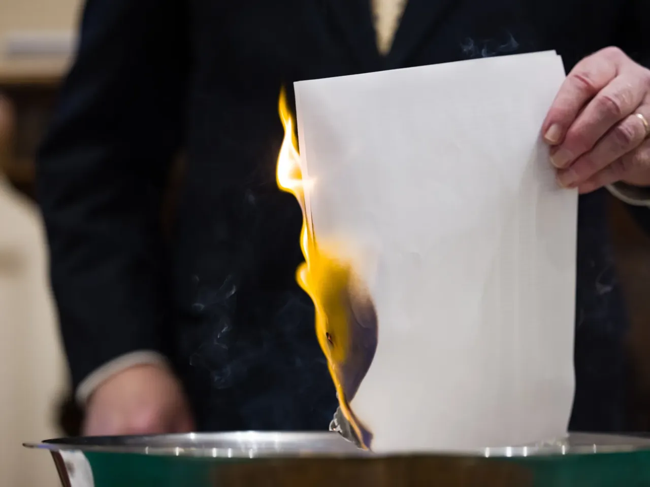 The Rev. John Jackman burns a list of names of people in surrounding Forsyth County whose debt was purchased and retired by the church.