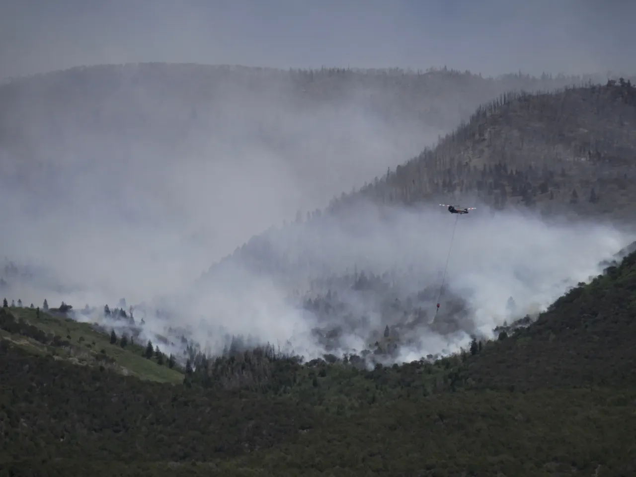 A helicopter drops water on the Cottonwood Fire in Beaver, Utah, on Saturday, June 27, 2026.