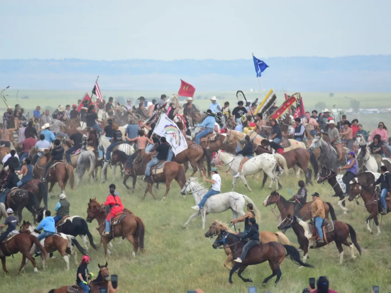 Horse mounted riders circle atop a hill at the Battle of Little Bighorn National Monument, near Last Stand Hill, on June 25.