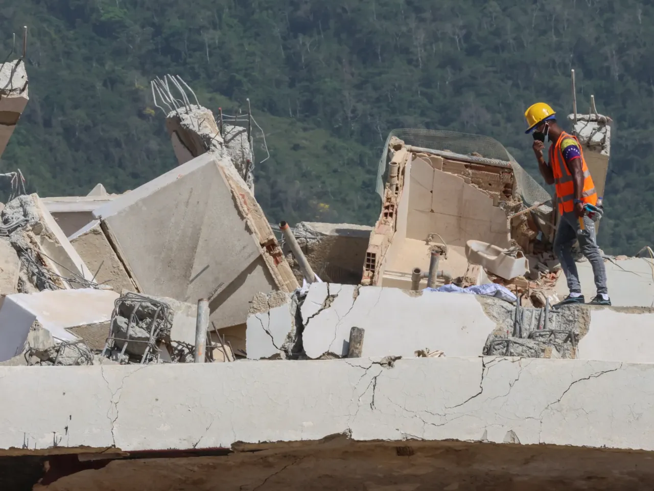 A person searches for victims on June 27 amid debris of a collapsed building after powerful earthquakes struck Venezuela, in Los Corales, Venezuela.