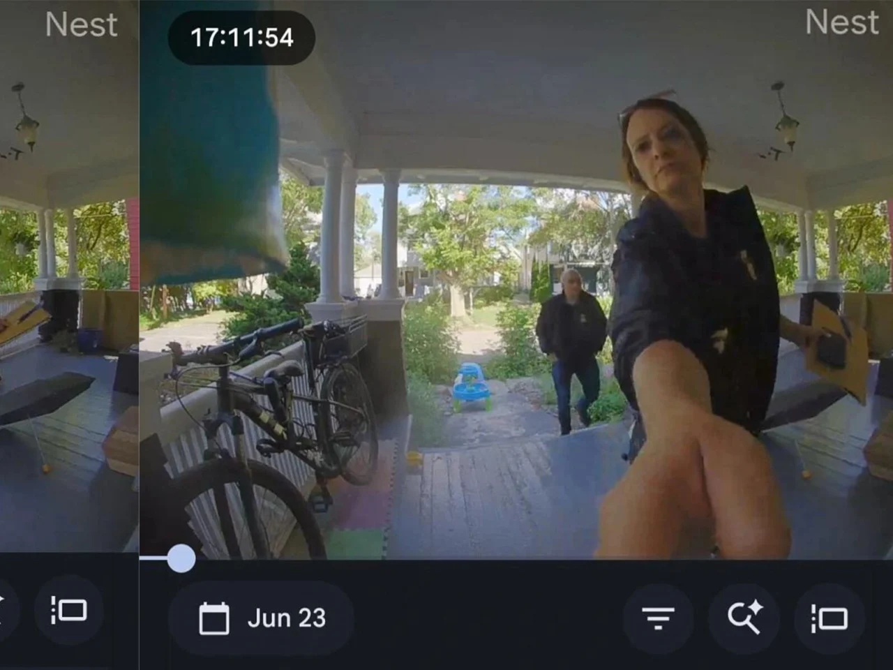 Two federal agents in blue jackets stand on David Streever's porch at his home in Rochester, N.Y.