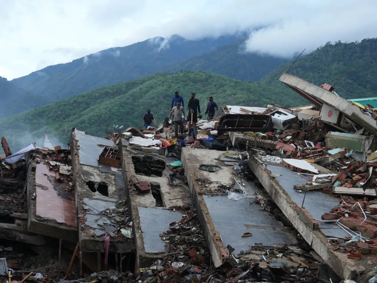 Residents on Tuesday search through the rubble of a building that collapsed in the June 24 earthquakes in La Guaira, Venezuela.