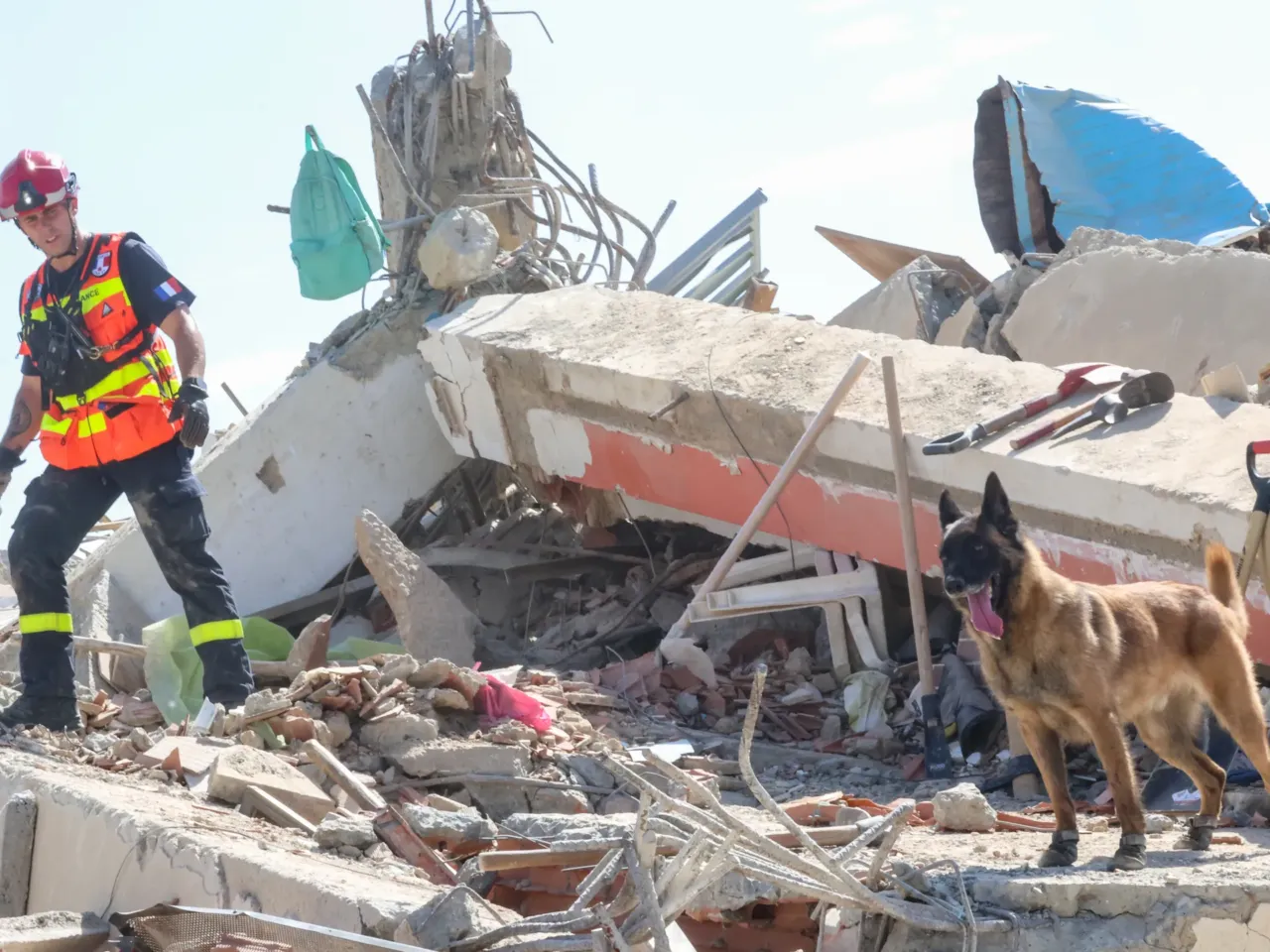 A member of the French Civil Security Training and Intervention Regiment with his dog search for victims amid debris of a demolished building at Los Corales on June 27, after powerful earthquakes struck Venezuela, in La Guaira, Venezuela.