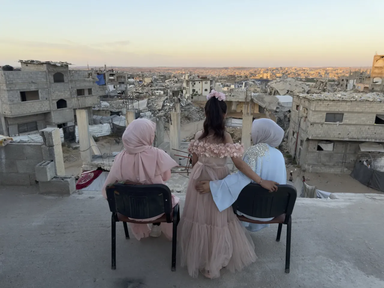9 months into a ceasefire, Israel now controls nearly 70% of Gaza 8 Three sisters sit looking out over a sea of debris as the sun sets in northern Gaza's militarized orange zone of Beit Lahia, on May 31.