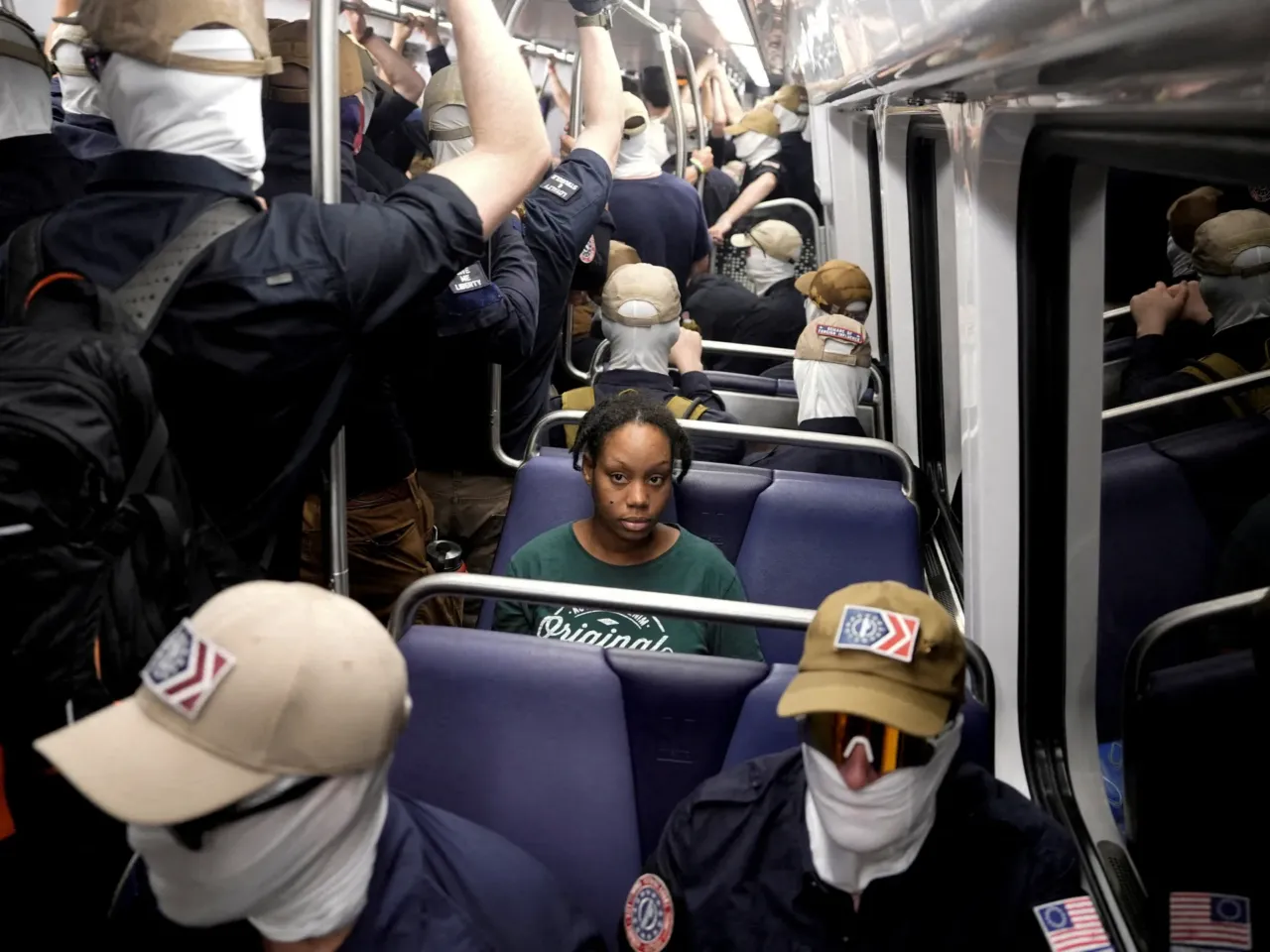 Members of the group Patriot Front ride the subway as a commuter looks on, in Washington, D.C., on July 4.