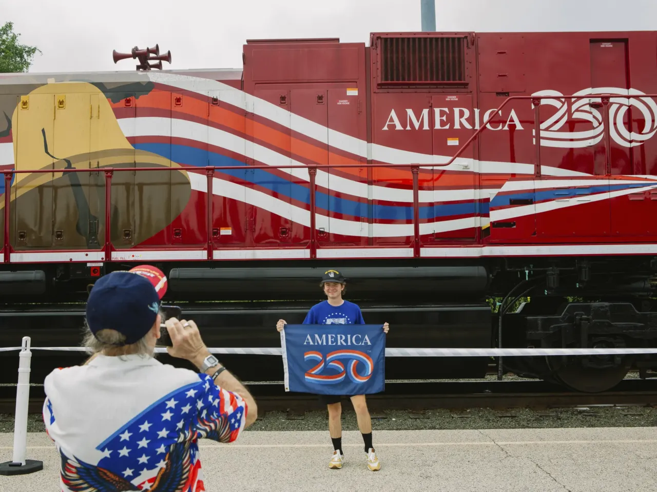 The biggest steam locomotive is whistle-stopping across the U.S. 1 Adam Lapham, 25, of Green, Ohio, stands for a photograph taken by his grandfather, James Wallace, 74, in front of a train car connected to Union Pacific's Big Boy No. 4014, the world's largest operating steam engine locomotive, during a stop in Philadelphia.