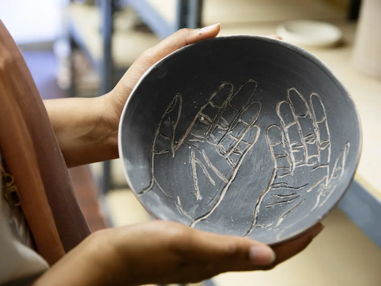 What do a bar and a Muslim community organization have in common? 11 Sellars displays a bowl she made in the ceramics studio.