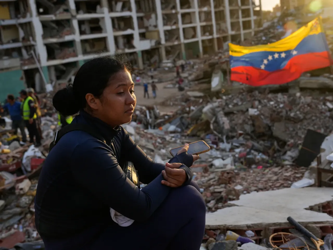 Estefany Landaez sits amid the rubble of a building, waiting to find her two children after the earthquakes in La Guaira, Venezuela,  July 12, 2026.