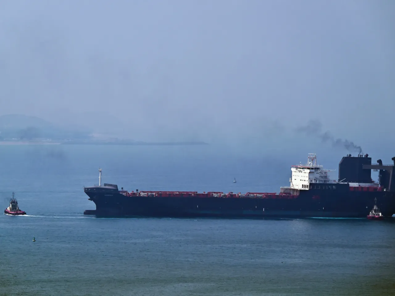 A tugboat guides a ship at the Khor Fakkan Container Terminal, the only natural deep-sea port in the region and one of the major container ports in Sharjah Emirate, along the Gulf of Oman, on July 14.