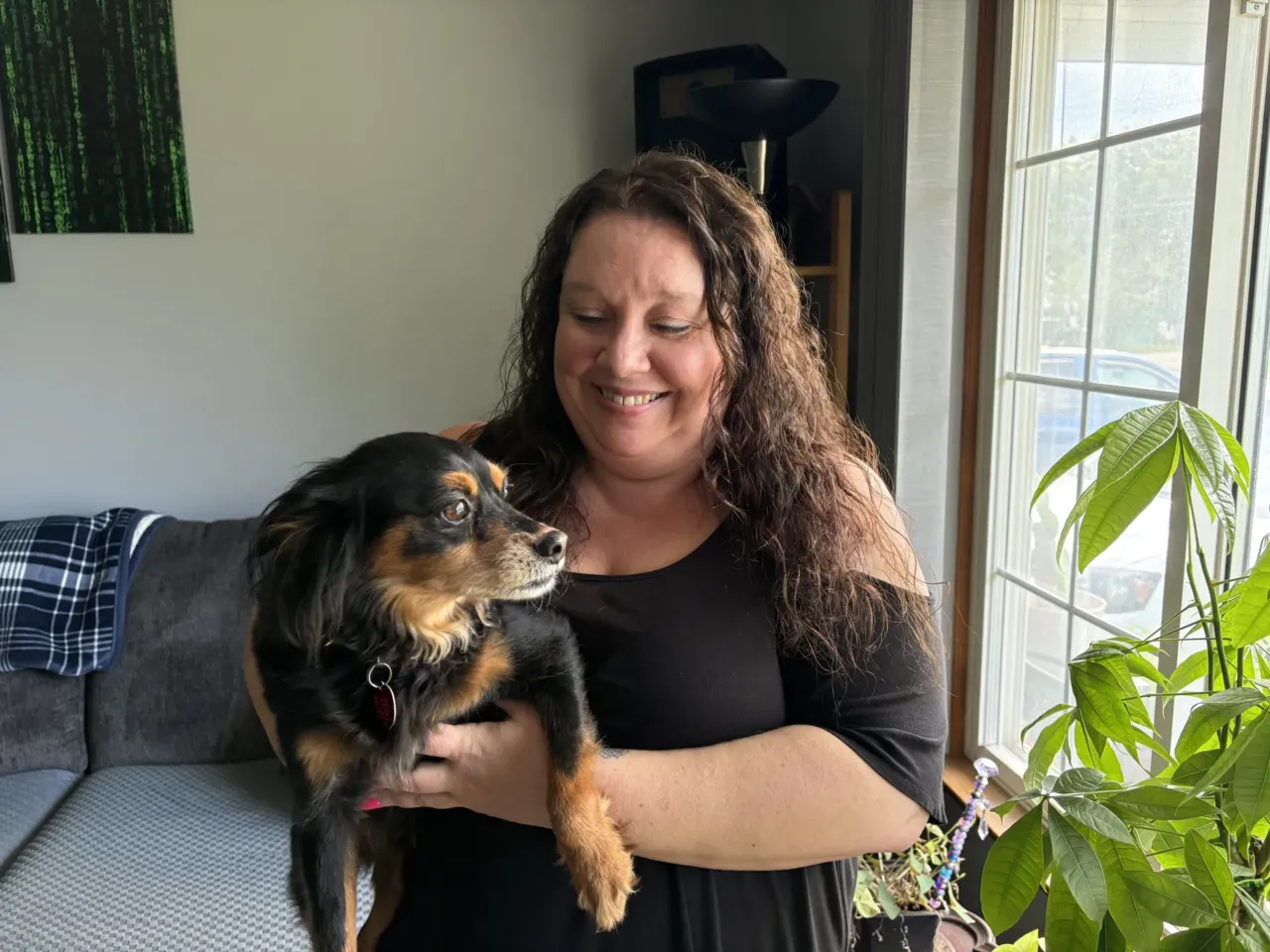 Marie Noon at her home in Brighton, Michigan, with her dog, Ziggy. Despite being eligible for Medicaid, Marie was denied coverage in 2025 because of an error with the state's benefits system. It took months of pushback before the state reversed its mistake. Even as a "tech-savvy" former bank manager, Marie says, she wanted to give up several times along the way.