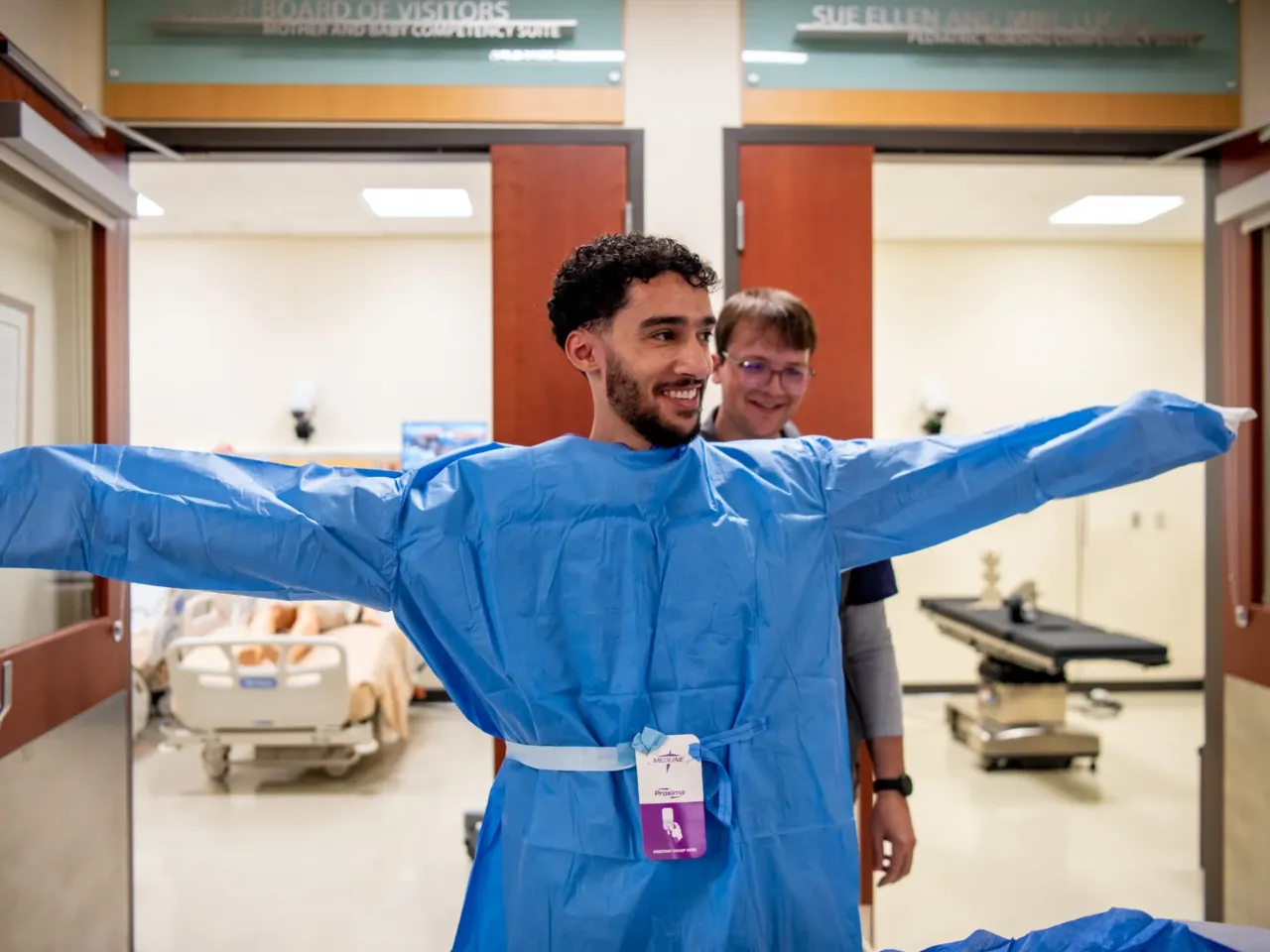 Hatim Nasser practices putting on a sterile gown for surgery. He started out studying computer science but hated it. He switched to nursing because he wanted to be able to help people. "Just caring for them and helping them feel comfortable," he says.