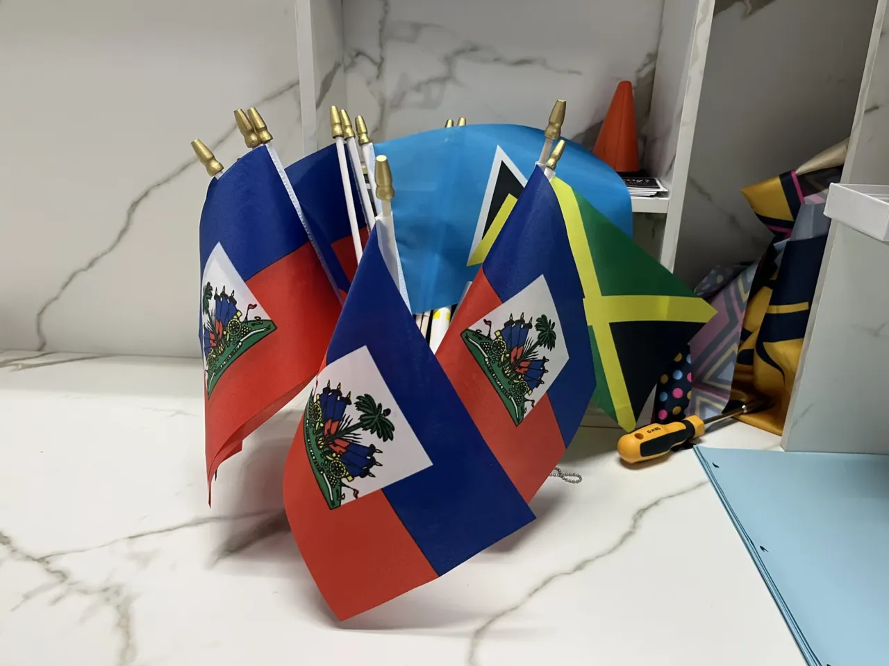 Families brace for separation as Haitians set to lose protected status next week 3 Haitian flags at the offices of the Haitian Bridge Alliance, a San Diego nonprofit.