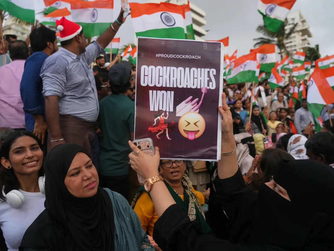 A protester holds a placard after India's Education Minister Dharmendra Pradhan resigned following nationwide protests as part of the Cockroach Janta Party's protest movement in Mumbai, India on Saturday.