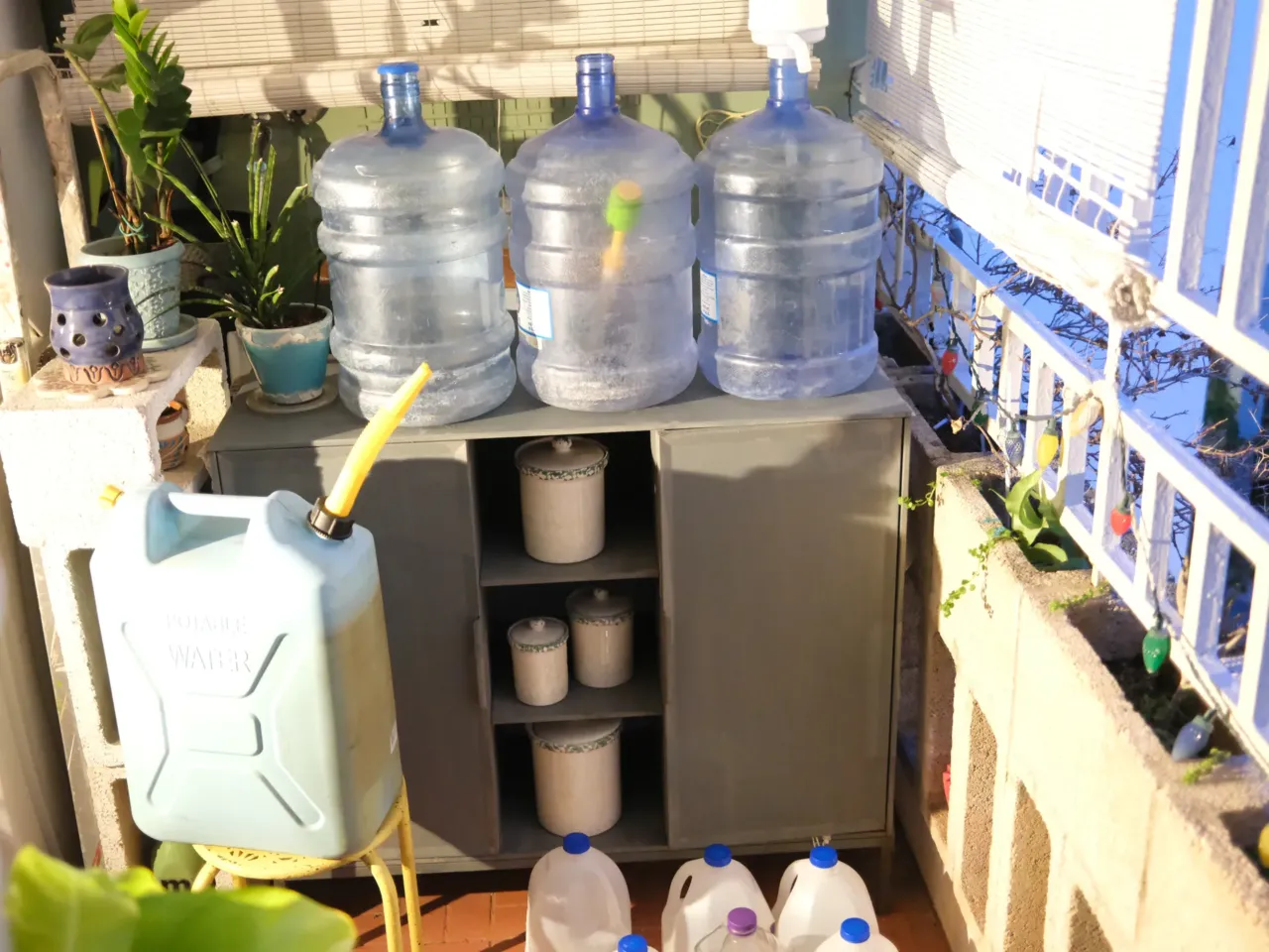 Water jugs litter the patio of a third-floor apartment, which is too high for water to reach even on days when the first floor gets just a trickle because of low pressure.